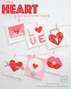 Six heart quilt blocks hanging on the wall.