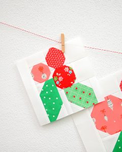 6 Inch Holly Berry quilt block hanging on a wall